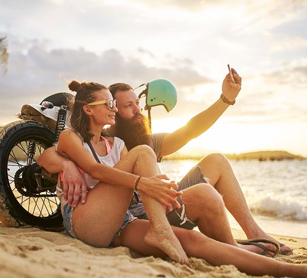 Couple in Thailand taking a selfie on the beach.