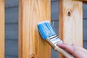 Paint brush on a wooden fence.